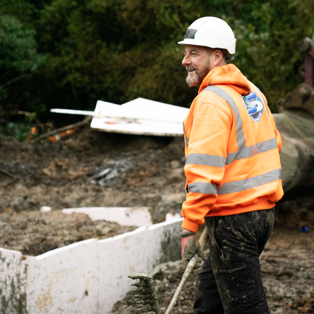 SS Construction groundworker smiling on site next to insulated formwork for a foundation pour