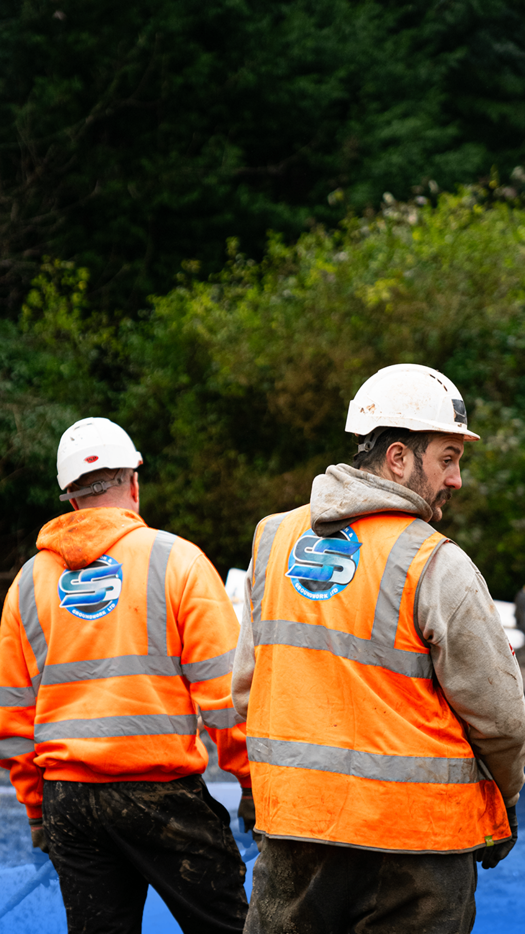 Two SS Construction operatives standing on a commercial site in branded PPE