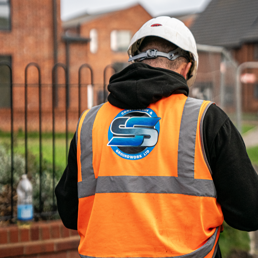 Close-up of the SS Construction & Groundwork Ltd logo on a team member's hi-vis vest